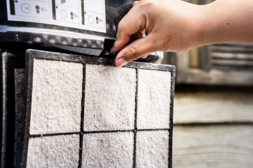 A human hand is removing the filter of an air purifier, for filtering PM2.5.