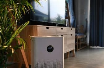 Close up view of portable air purifier on wooden floor in comfortable home for improve air quality.